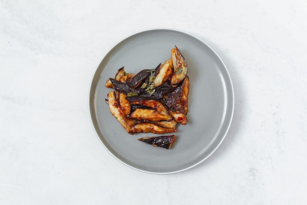 Crispy fried eggplant slices arranged on a ceramic plate
