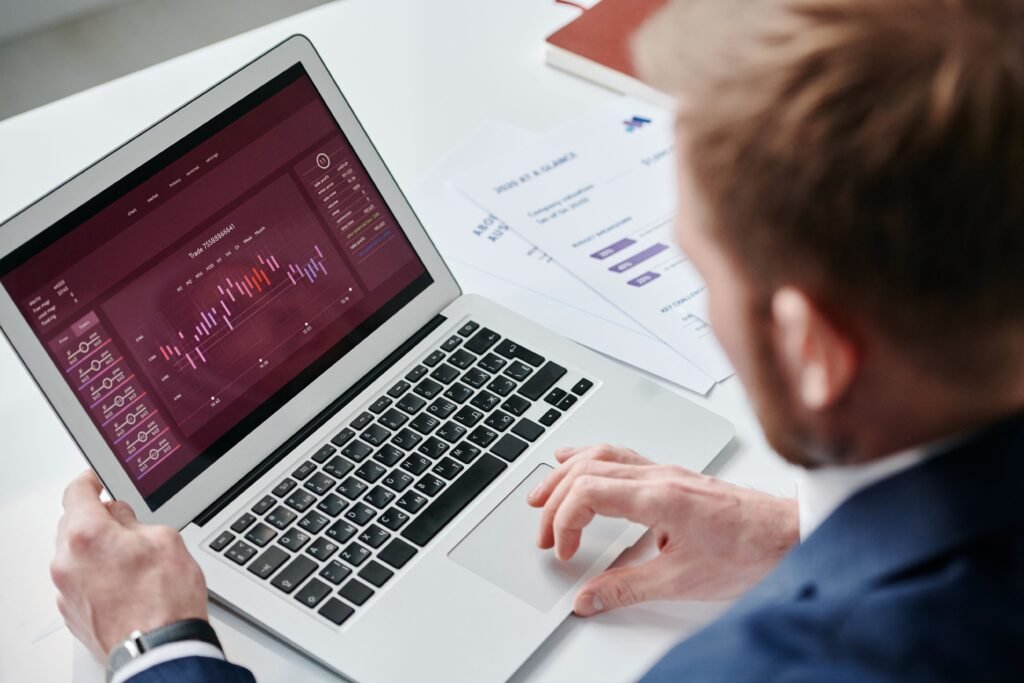 Professional reviewing financial data analytics on a laptop dashboard