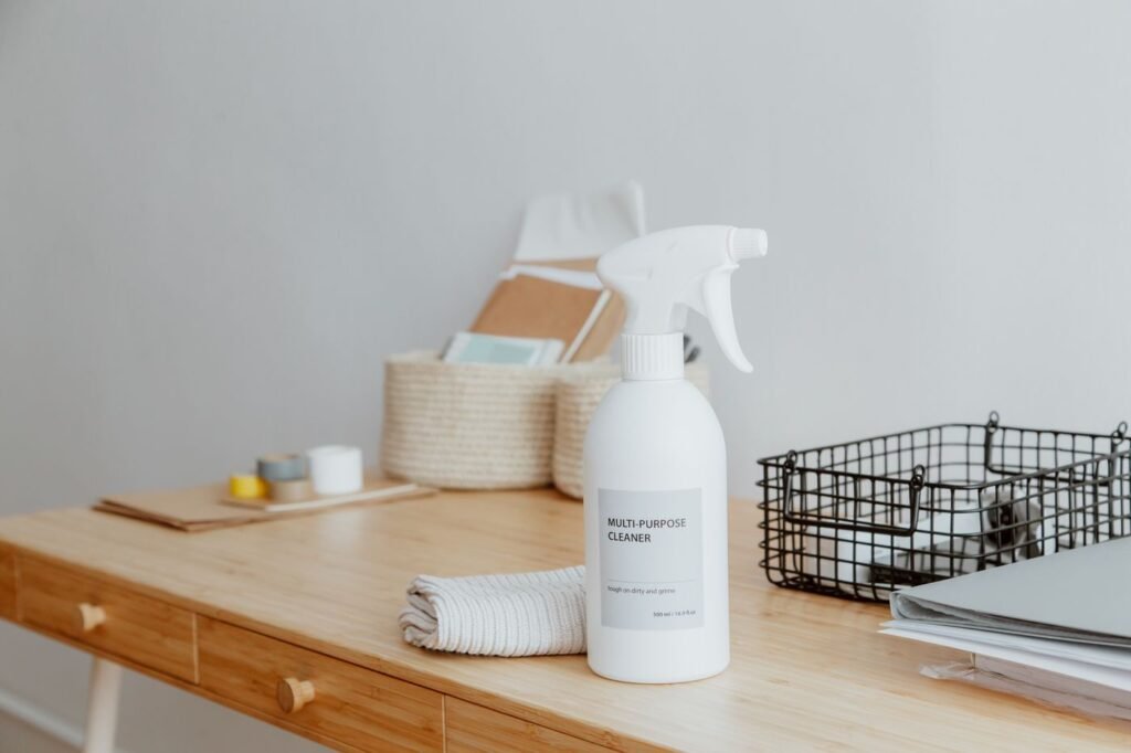 Spray bottle of multi-purpose cleaner and a folded cleaning cloth for floor cleaning
